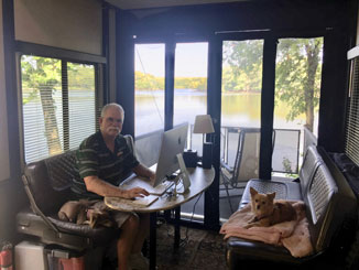 Ron sitting in office by a lake